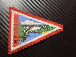 Heinola -kangasmerkki / matkailumerkki / hihamerkki / badge -pohjaväri punainen