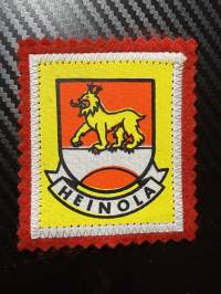 Heinola -kangasmerkki / matkailumerkki / hihamerkki / badge -pohjaväri punainen