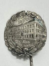 Åbo klassicka lyceum LX -neulamerkki, 813 hopeaa -koulun 70-vuotismerkki